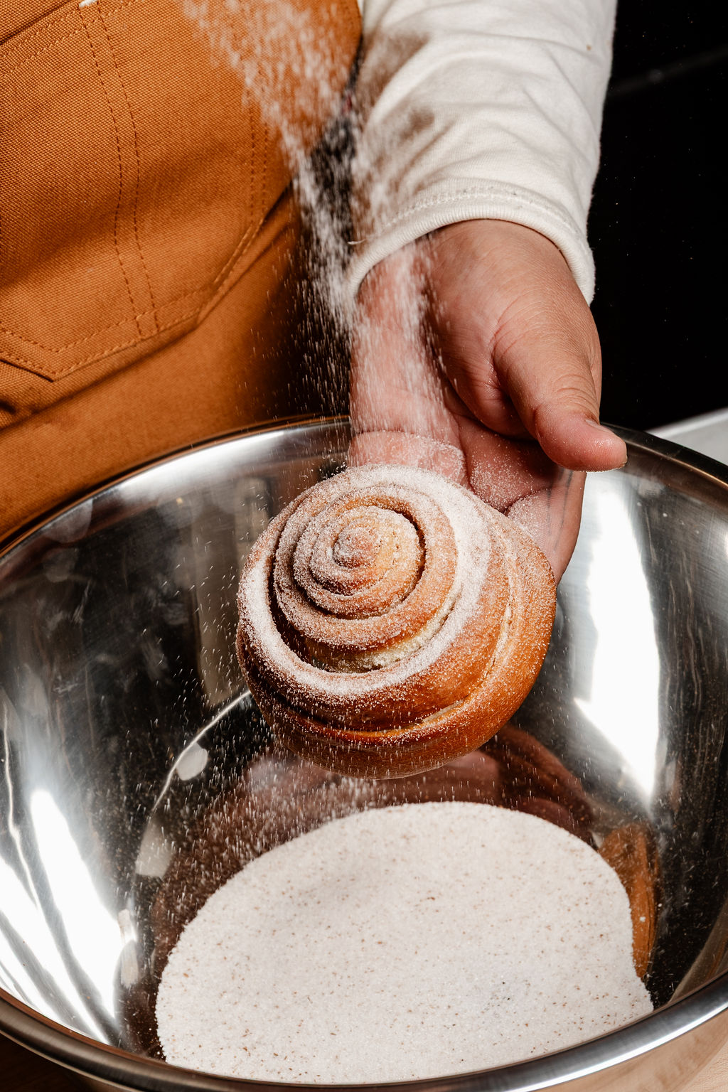 Sugar falling over a cinnamon roll