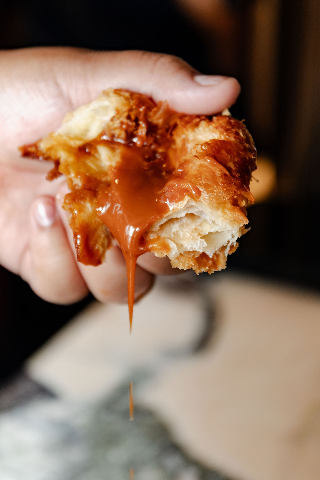 Cajeta spilling from a torn kouign amann