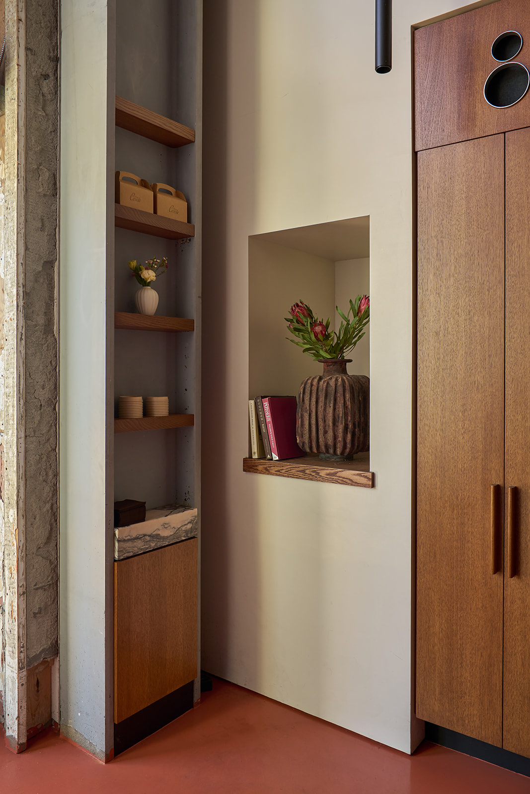 Shelving and a plaster niche with flowers